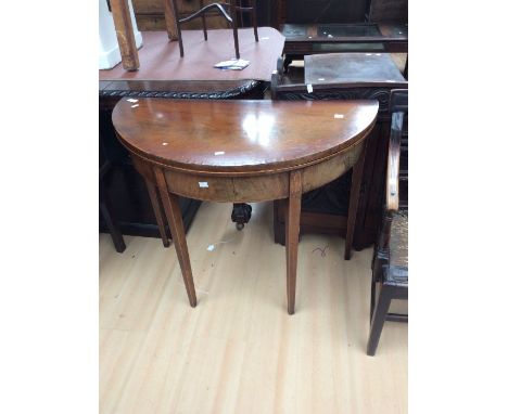 A late George III demi lune mahogany card table, on tapered legs, with shell detail, top opens out to reveal felt playing sur