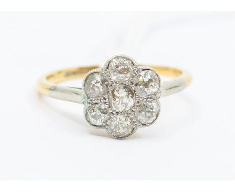 An early 20th century diamond and 18ct gold flower head cluster ring, set with old cut diamonds with a total diamond weight a