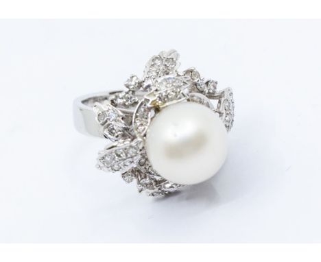 A cultured pearl and diamond white metal cluster ring comprising a round white cultured pearl with pink overtones, size appro