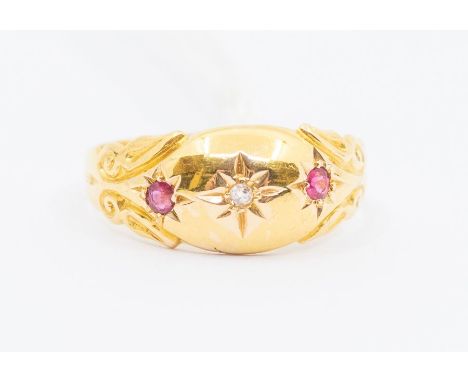 A Victorian ruby and diamond 18ct gold ring, set to the centre with a small diamond set either side with small rubies, scroll