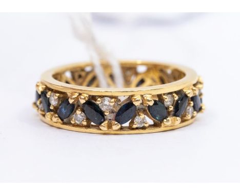 A sapphire and diamond 18ct gold eternity ring, comprising a central row of alternating marquise cut sapphires and round bril