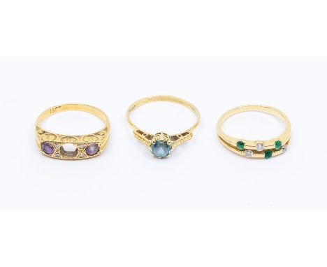 Three 18ct gold gem set dress rings to include a diamond and emerald double row ring set with three diamonds and three round 