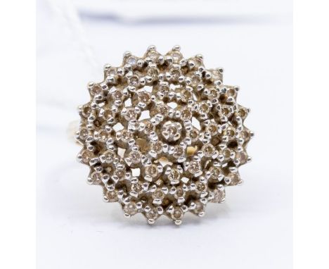 A diamond and 9ct gold cluster ring, comprising a circular domed open work setting in a star formation set with small brillia