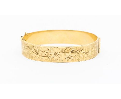 A 9ct gold bangle hinged bangle, flat section with engraved decoration, width approx. 12mm, internal diameter approx. 57mm, w