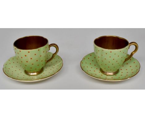 Carlton Ware: A pair of Carlton Ware cups and saucers green ground with orange dots, gilded interior and handles, height appr