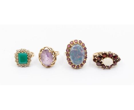 A collection of four vintage 9ct gold gem set dress rings to include an opal doublet and ruby ring, comprising an oval opal d