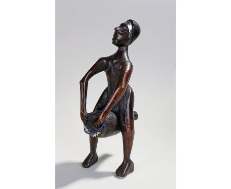 African carved figure, with long arms playing a drum, 34cm high