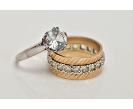 TWO YELLOW METAL SPINEL SET DRESS RINGS, the first a full eternity ring, textured rim set with a row of colourless spinel's, 