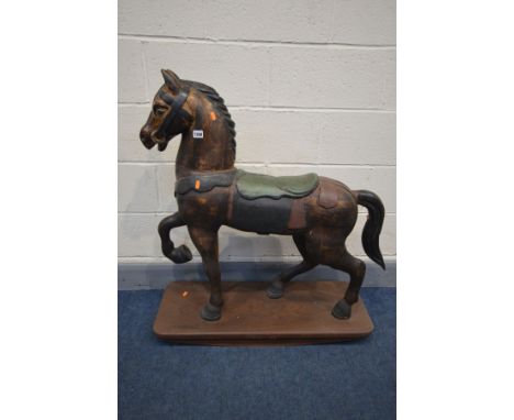 A HARDWOOD ROCKING HORSE raised on a plinth, length 90cm x height 98cm (condition - loose tail)