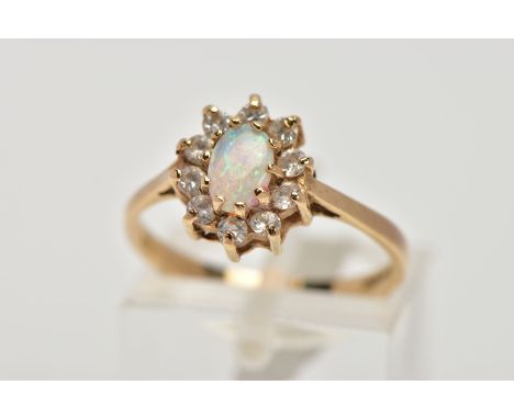 A 9CT GOLD OPAL CLUSTER RING, designed as a central oval opal cabochon within a circular cut cubic zirconia surround, 9ct hal