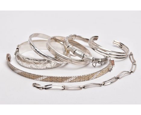 A PARCEL OF SILVER AND WHITE METAL BANGLES AND BRACELETS, to include a wide silver hinged bangle, decorated with an engraved 