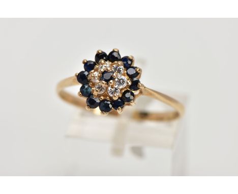 A 9CT GOLD SAPPHIRE AND CUBIC ZIRCONIA CLUSTER RING, raised cluster set with a central circular cut blue sapphire within a su