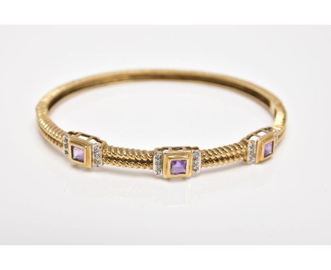 A 9CT GOLD AMETHYST AND DIAMOND HINGED BANGLE, the bangle with a twist pattern, set with three square cut amethysts each flan