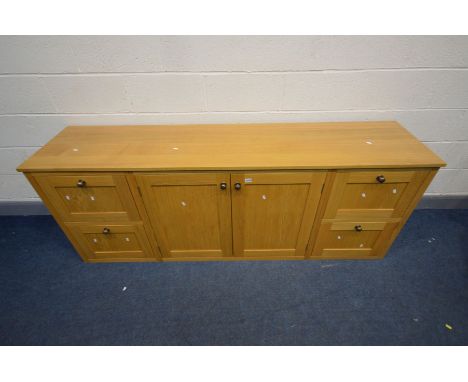 A LIGHT OAK SIDEBOARD with four deep drawers flanking double cupboard doors, width 204cm x depth 50cm x height 79cm (conditio