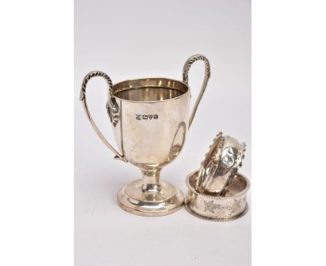 A MINIATURE SILVER TROPHY CUP AND TWO SILVER NAPKIN RING, plain polished body raised on a circular stepped base, fitted with 