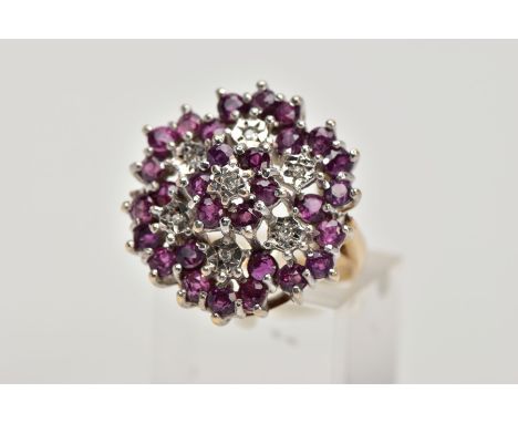 A 9CT GOLD RUBY AND DIAMOND CLUSTER RING, designed as a tiered cluster of single cut diamonds and circular cut rubies within 