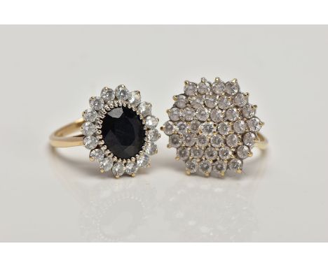 TWO 9CT GOLD DRESS RINGS, the first a cubic zirconia cluster ring, ring size K, the second designed as a central oval sapphir