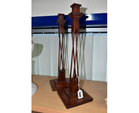 A PAIR OF 20TH CENTURY MAHOGANY AND STAINED CANDLESTICKS, square holder above four slender twisted open supports to a block b