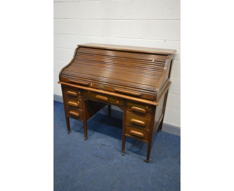 AN EARLY 20TH CENTURY OAK AMYL ROLL TOP DESK, the top with a fitted interior, on a pair of pedestals with two brushing slides