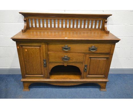 MAPLE AND CO, AN ARTS AND CRAFTS OAK SIDEBOARD, with a raised spindled back, above an arrangement of two drawers and two cupb