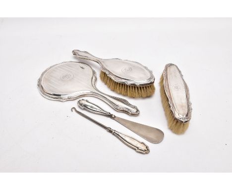 A THREE-PIECE SILVER VANITY SET A BUTTON HOOK AND A SHOEHORN, the vanity set comprising of a hairbrush, clothes brush and mir