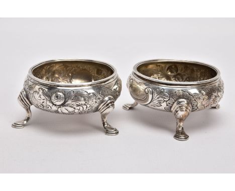 A PAIR OF GEORGE II OPEN SILVER SALTS, cauldron shape, embossed floral design, vacant cartouche, raised on three stepped pad 