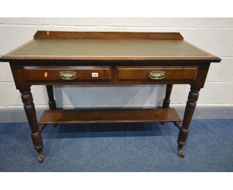 AN EDWARDIAN MAHOGANY DESK with a raised back, green leather inlay, on turned legs united by a under shelf, on ceramic caster