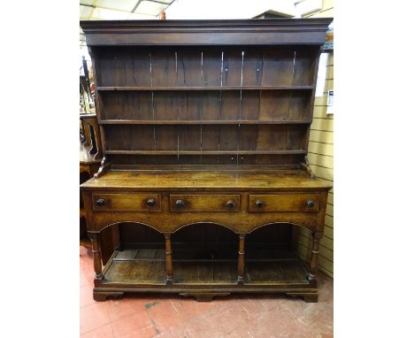 A CIRCA 1820 WELSH OAK POTBOARD DRESSER, with three shelf boarded rack over a two plank rectangular top with three pine lined