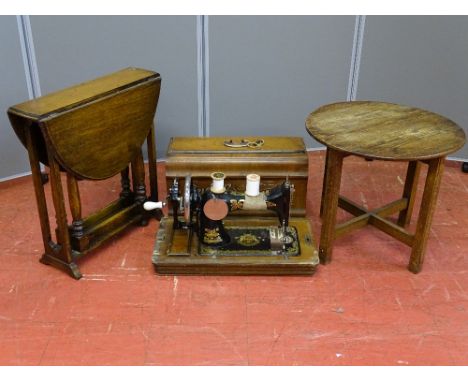 A SMALL OAK DROP LEAF GATE LEG COFFEE TABLE, a circular occasional table and a Frister &amp; Rossman hand sewing machine in a