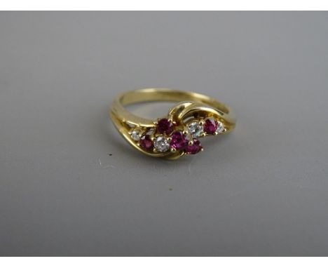 A NINE CARAT GOLD RUBY &amp; DIAMOND CROSSOVER DRESS RING, 2.9 grms, size mid 'O' to 'P'