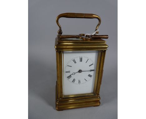 A DROCOURT FRENCH BRASS CASED CARRIAGE CLOCK with visible escapement, the white dial set with Roman numerals, trademark DC wi