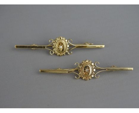 A PAIR OF NINE CARAT GOLD BAR BROOCHES with oval pearl set centres, 4.2 grms