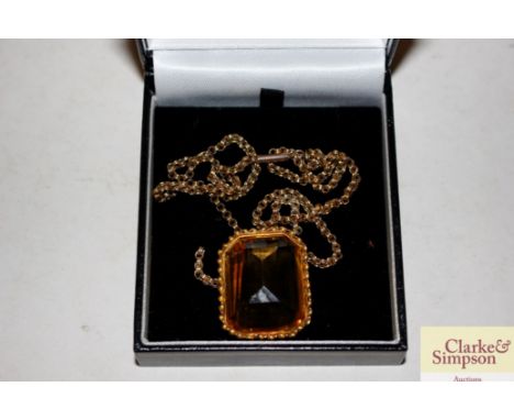 A yellow metal and amber coloured pendant on 9ct gold chain
