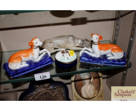 A pair of Staffordshire type greyhound ornaments; a porcelain recumbent hound; and a Halcyon Days enamel hinged box with span