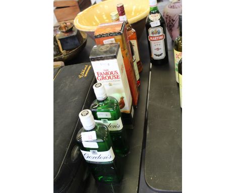 A bottle of Famous Grouse Scotch whisky (boxed), two bottles of Gordons Dry Gin, a bottle of Metaxa Amphora (boxed) and three