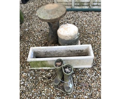 A selection of concrete garden planters in the form of a mushroom, a long trough and a pair of wellington boots