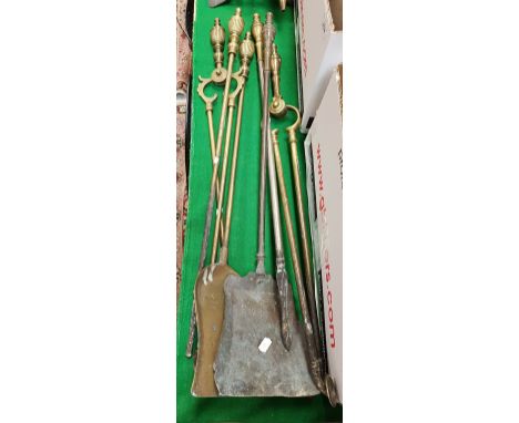 Two sets of Edwardian brass fire tools comprising poker, tongs and shovel together with a pair  of fire dogs, a pair of bello
