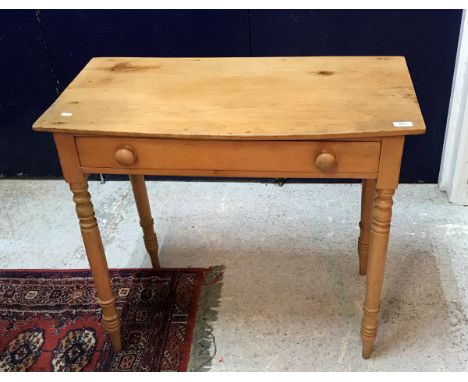 A pine single drawer side table with bow fronted top raised on turned legs 