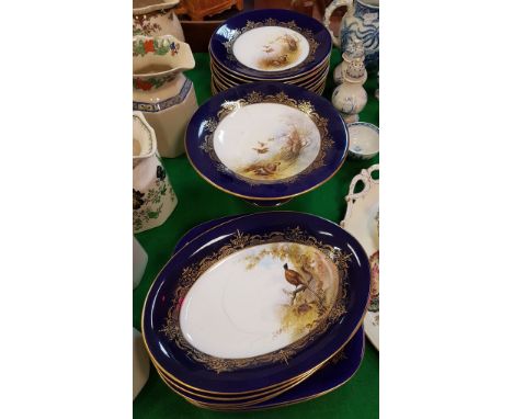 A collection of Royal Worcester game decorated dessert plates including circular plates and serving dishes all painted by G. 