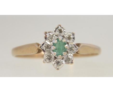 A 9ct gold, emerald and diamond ring. The central oval emerald with diamond surround. Size R /Weight 1.6g, The ring hallmarke