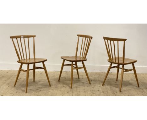 Ercol, a set of three beech and elm model 737 chairs, with comb backs, shaped seats and raised on turned supports united by s