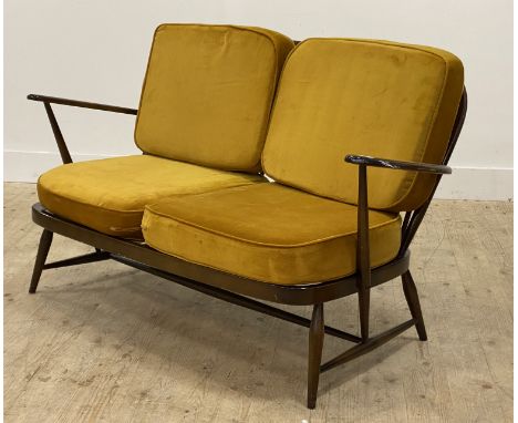 Ercol, a vintage two seat sofa, with hoop and spindle back, and open arms enclosing yellow velvet squab cushions, raised on t