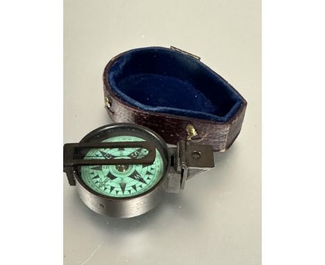 A brass cased pocket compass with green dial with lower section of original case, ( D&nbsp; x 4 cm)&nbsp;