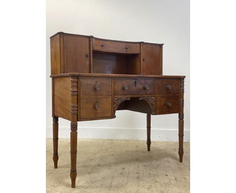 A mid 19th century mahogany writing desk, the superstructure with a concave centre drawer flanked by four turned pilasters an