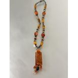 A white metal beaded carnellian bead necklace with rectangular oval panel with relief carved