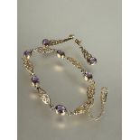 A 9ct gold Celtic knot line style bracelet set five oval amethysts in rub over setting with safety