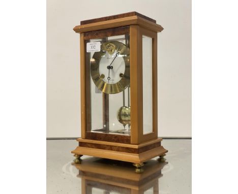 A Franze Hermle &amp; John four glass clock, the case with burr elm veneers, bevelled glass panels, and brass supports enclos