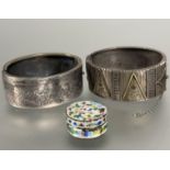 A silver Edwardian stiff hinged bangle with engraved floral panels and safety chain, (H x 2.5 cm x D