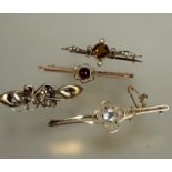 A Edwardian yellow metal aquamarine bar brooch, the centre stone in rub over setting flanked by four