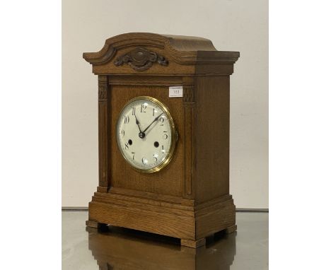An early 20th century bracket clock, the moulded oak case enclosing a white enamel dial with Roman chapter ring, eight day mo